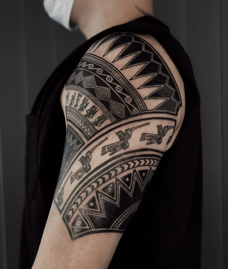 Tattoo hoa văn bắp tay nam với nét mực sắc sảo