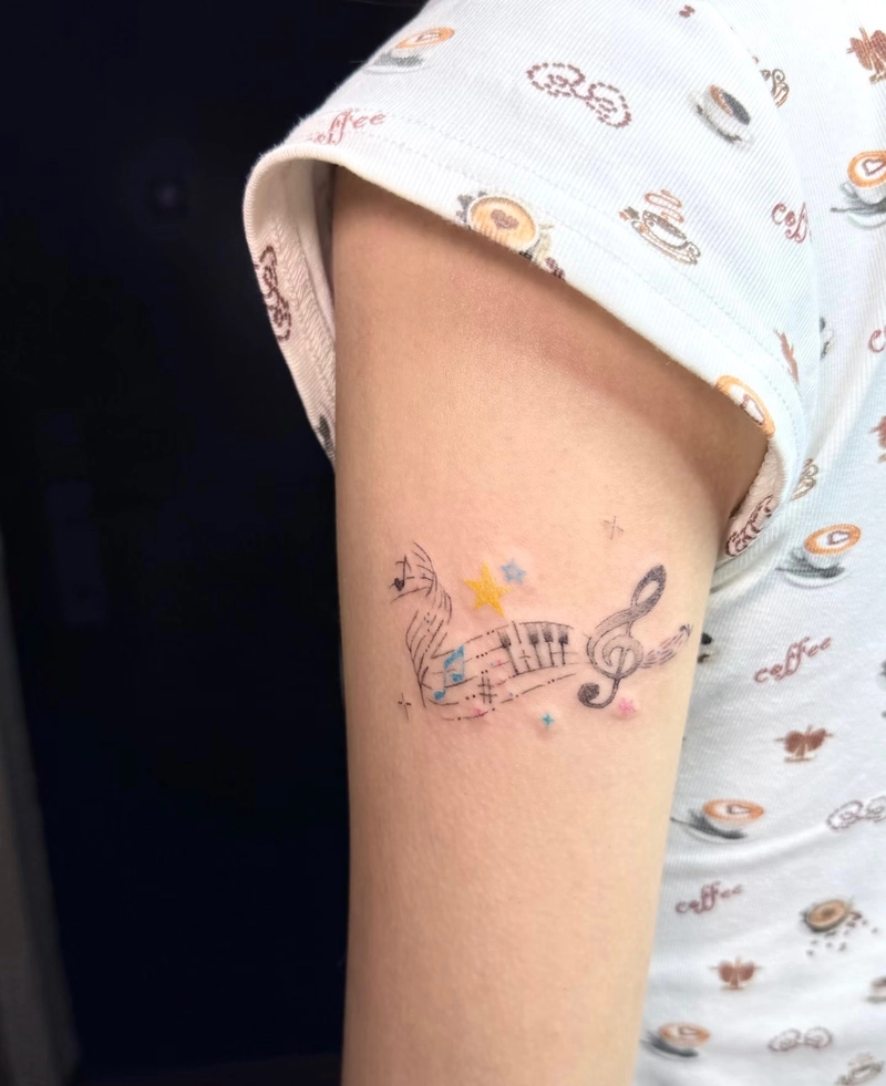 tattoo nốt nhạc và hình họa tiết ở bắp tay